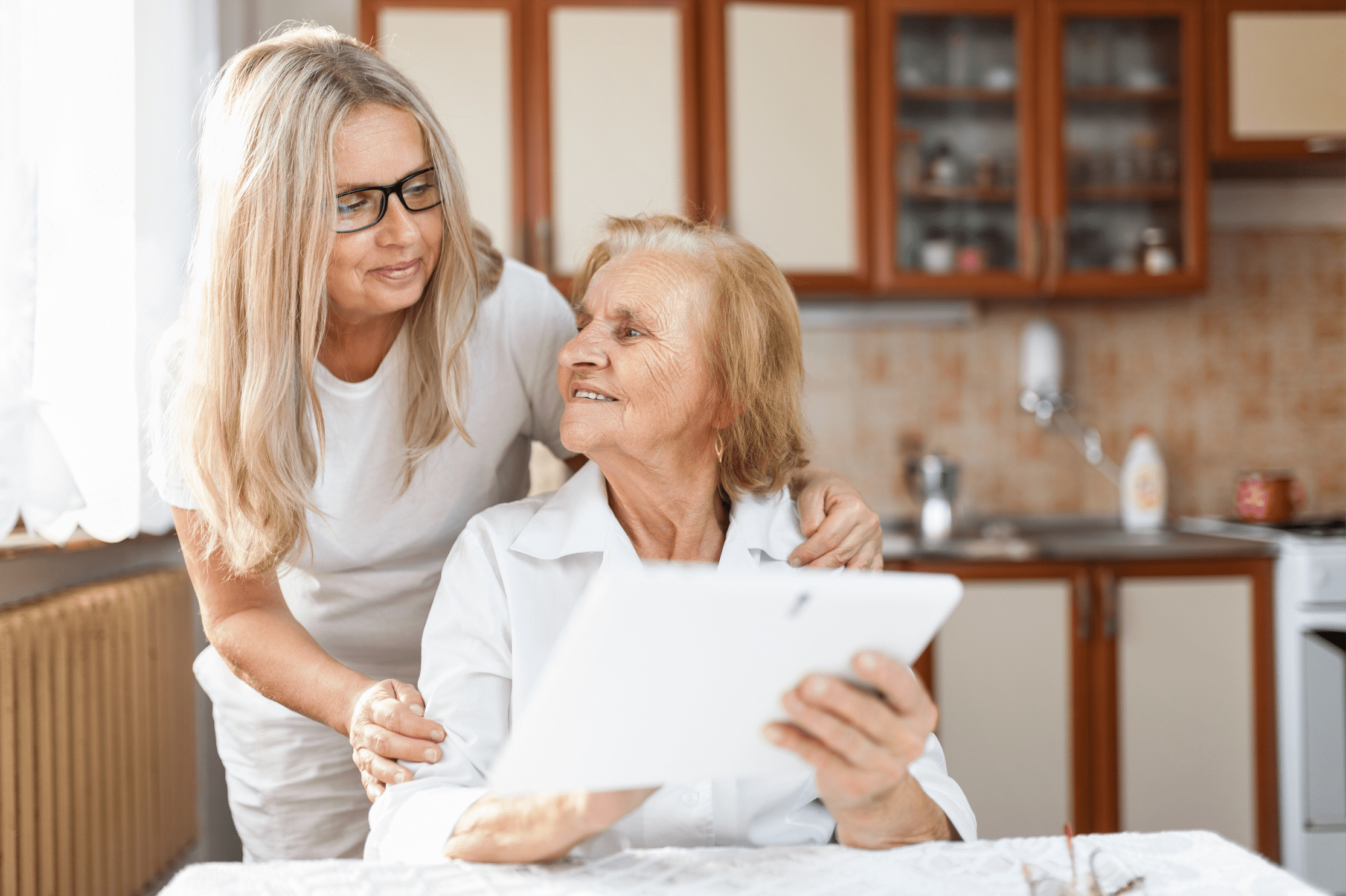 A woman and her mother sit reviewing their choices for aged care near me.